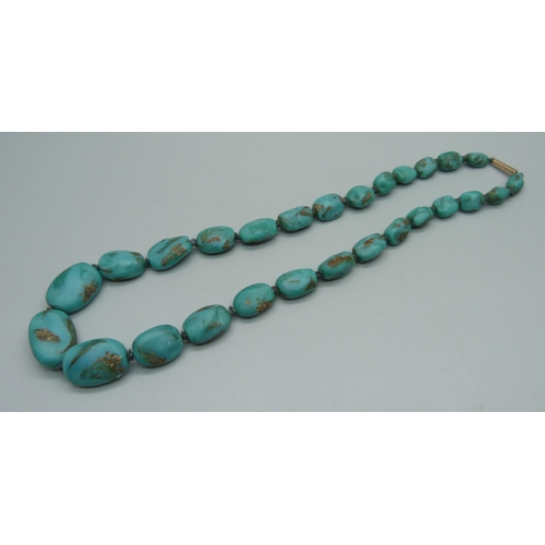 1143 - A string of turquoise beads on a 9ct gold clasp