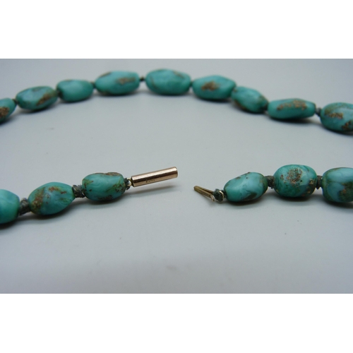 1143 - A string of turquoise beads on a 9ct gold clasp