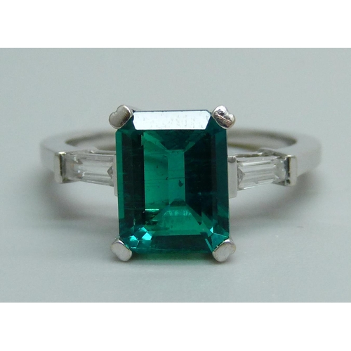 1163 - An 18ct white gold ring set with diamond shoulders and a synthetic emerald, 4.1g, L