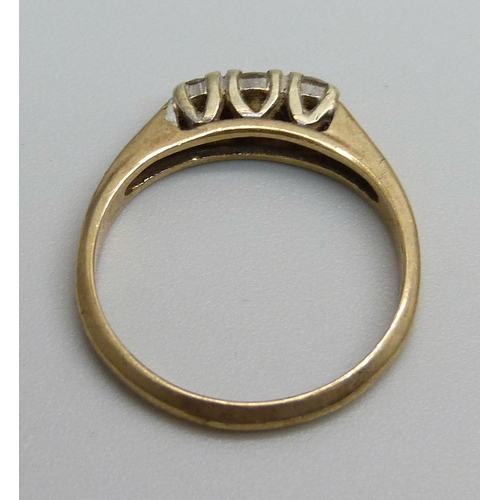 1168 - A 9ct gold ring set with three diamonds, 2.2g, M