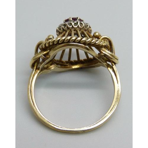 1170 - A yellow metal ring of openwork design, set with a ruby and diamond cluster, tests as 15ct gold, 6g,... 