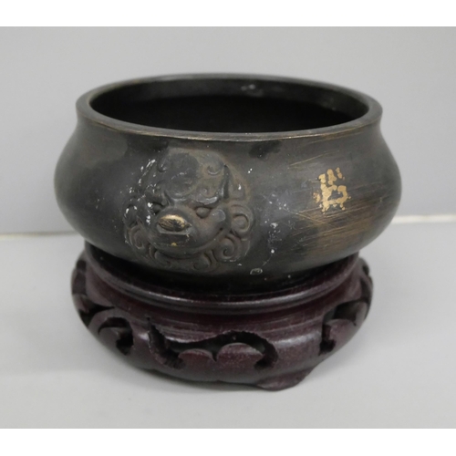 644 - A bronze censer, 14.5cm on a carved wooden stand