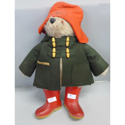 749 - A Paddington Bear soft toy, dark green duffel coat and red wellington boots