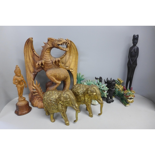 784 - A box of carvings including detailed model of a dragon, (small losses), a pair of Indian brass eleph... 