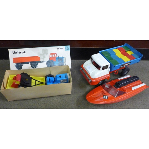 821 - A Tri-ang Transporter tipper truck, an Unitrak tractor and speed boat and trailer