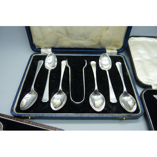 865 - Three cased sets of silver spoons, 162g, (one pair of sugar bows plated, one associated box, one spo... 