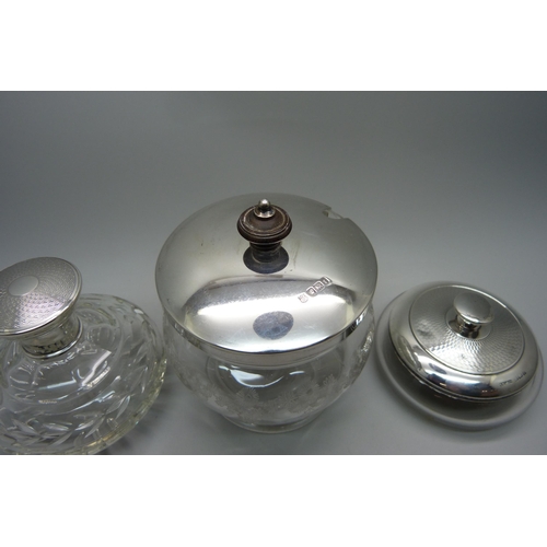 920 - A silver topped glass preserve jar, a silver topped scent bottle and a silver topped jar with mirror... 