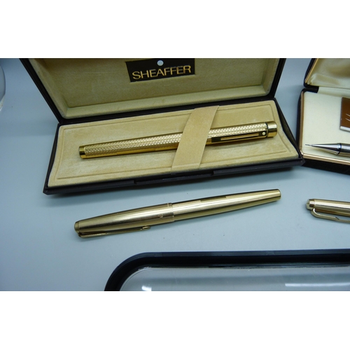 922 - A gold plated Sheaffer pen with 14ct gold nib, cased, two plated Parker pens and other pens