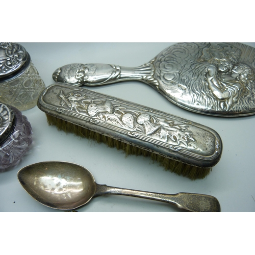 937 - Four silver topped dressing table jars, a silver hand mirror, silver spoons and a silver backed brus... 