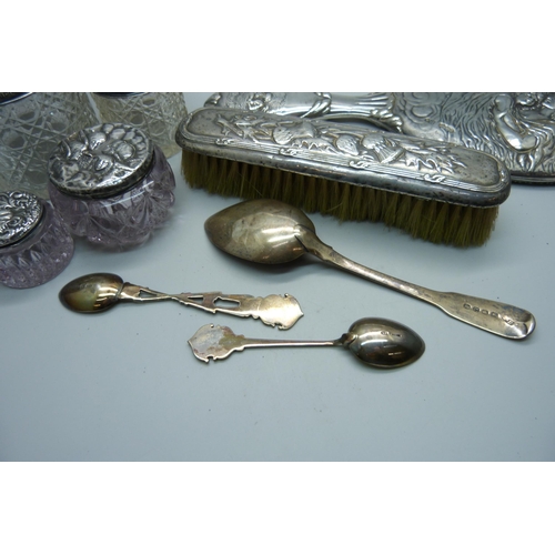 937 - Four silver topped dressing table jars, a silver hand mirror, silver spoons and a silver backed brus... 