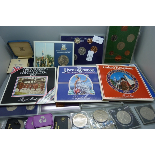 957 - A collection of coins, coin covers and a stamp cover, including two £5 coins, coin sets, etc.