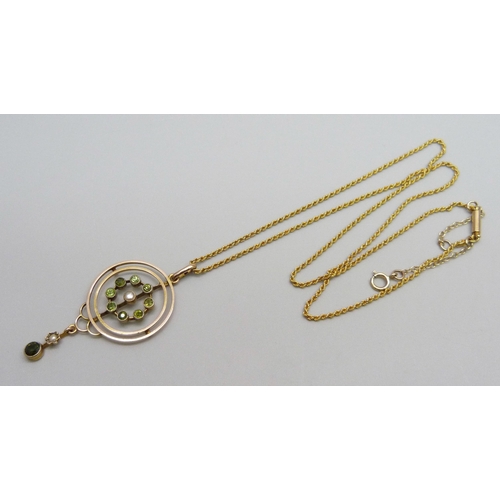 964 - A 9ct gold Edwardian drop pendant set with eight peridot stones and a central seed pearl with a peri... 