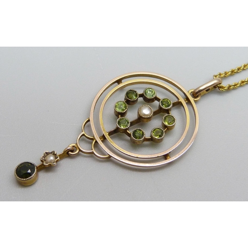 964 - A 9ct gold Edwardian drop pendant set with eight peridot stones and a central seed pearl with a peri... 