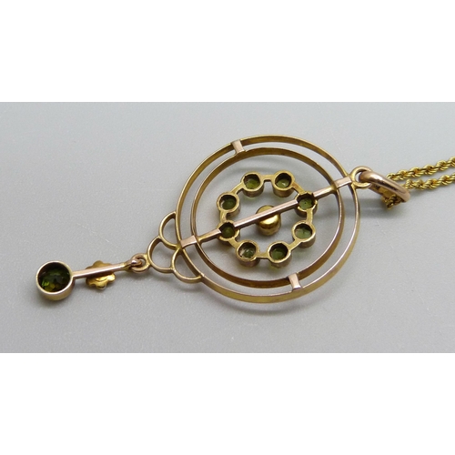 964 - A 9ct gold Edwardian drop pendant set with eight peridot stones and a central seed pearl with a peri... 