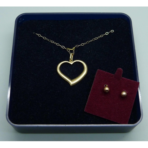 965 - A 9ct gold heart pendant on a fine 9ct gold chain, together with a pair of yellow metal earrings