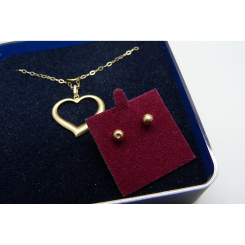 965 - A 9ct gold heart pendant on a fine 9ct gold chain, together with a pair of yellow metal earrings