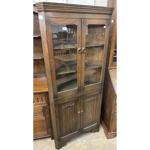 303 - A carved oak linenfold freestanding corner cabinet
