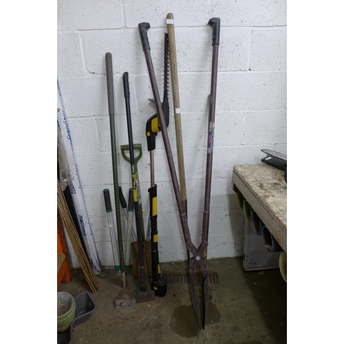 2214 - A bundle of garden tools including rakes, 3 hoes, spades, hedge trimmer, etc.