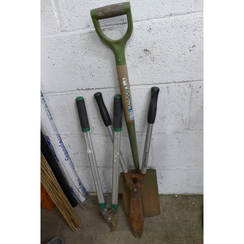 2214 - A bundle of garden tools including rakes, 3 hoes, spades, hedge trimmer, etc.