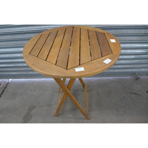 2253 - A teak circular folding garden table with a pair teak folding chairs and pastel green cushions