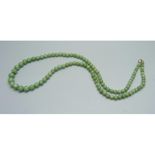 1038 - A jade necklace with a 9ct gold fastener, 42g