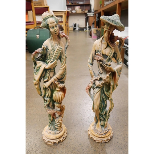 1182 - A pair of Chinese resin sculptures - hand carved male and female figures each holding various symbol... 