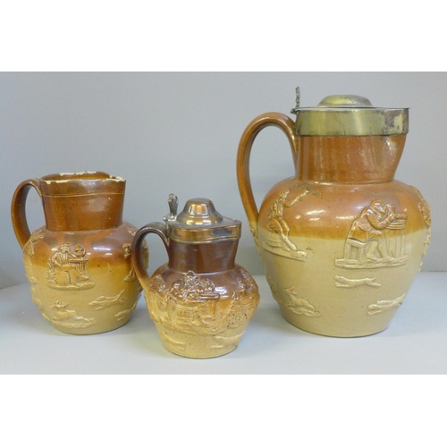 613 - Two lidded Victorian saltglaze jugs, one engraved with a lion and inscribed 
