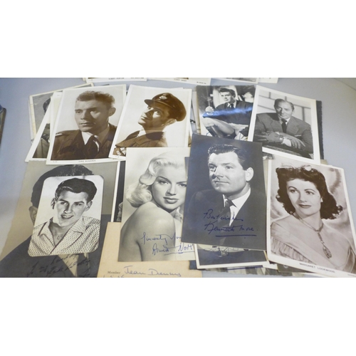 617 - A tin containing celebrity photographs and postcards, many with facsimile autographs including Dirk ... 