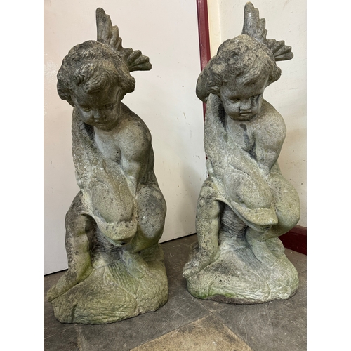 313 - A pair of concrete garden figures of a cherubs with fish