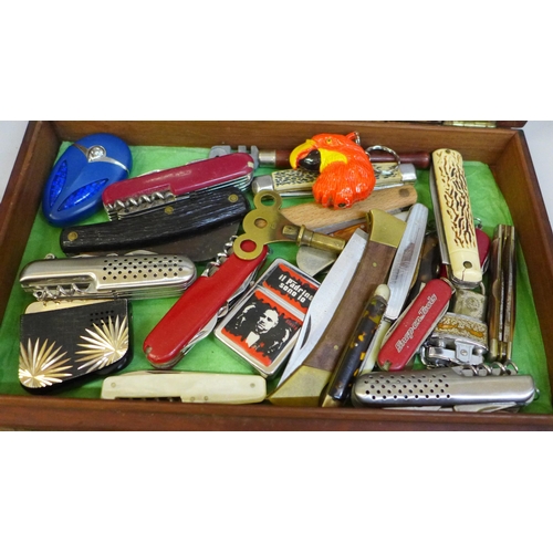 676 - A hinged display box of penknives, lighters, etc.