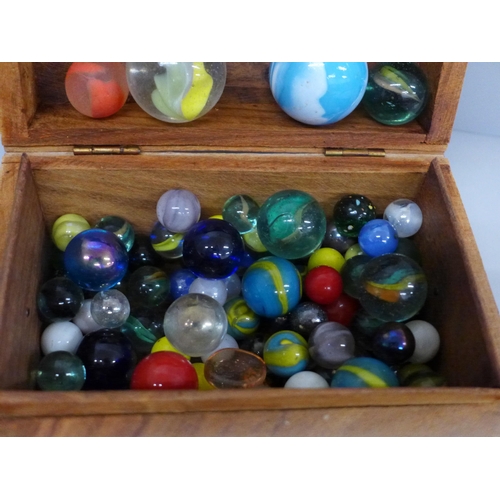 709 - A collection of marbles in a wooden box