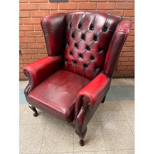 106 - An oxblood red leather wingback armchair