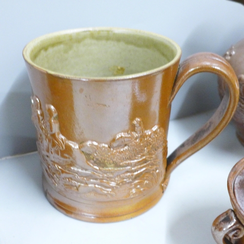 845 - A Victorian Brampton saltglaze jug, two mugs and a tobacco jar with a dog to lid, a/f (4)