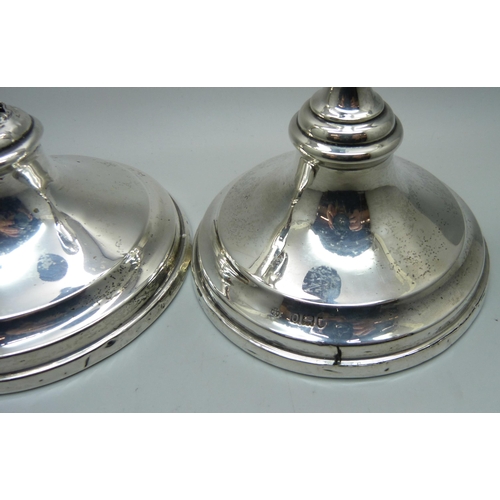 866 - A pair of silver candlesticks, weighted bases, one a/f