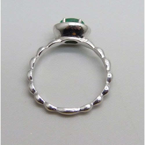 944 - A 14k white gold Zambian emerald and diamond ring, diamond 0.10 carat, emerald 0.45 carat