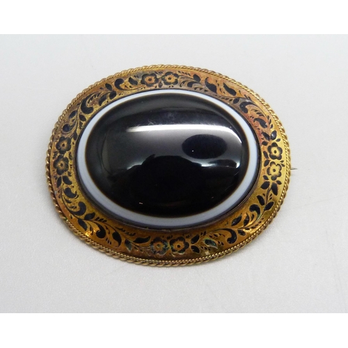 952 - A yellow metal, enamel and bulls-eye agate set brooch, 35mm x 42mm