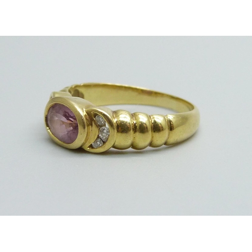 976 - A yellow metal ring set with a central amethyst and diamond shoulders, 4.5g, N