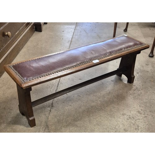 276 - An early 20th Century oak and leather bench