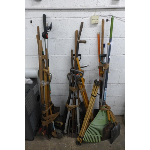 2145 - A large quantity of garden tools including drain rods, axes, sweeping brush, forks, spades, etc.