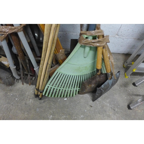 2145 - A large quantity of garden tools including drain rods, axes, sweeping brush, forks, spades, etc.