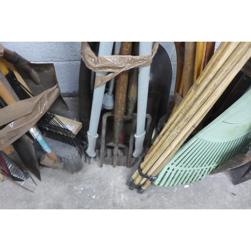 2145 - A large quantity of garden tools including drain rods, axes, sweeping brush, forks, spades, etc.