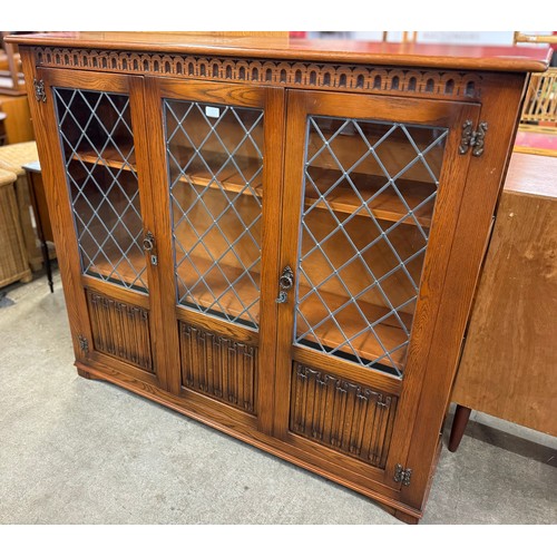 176 - A carved oak linenfold three door bookcase