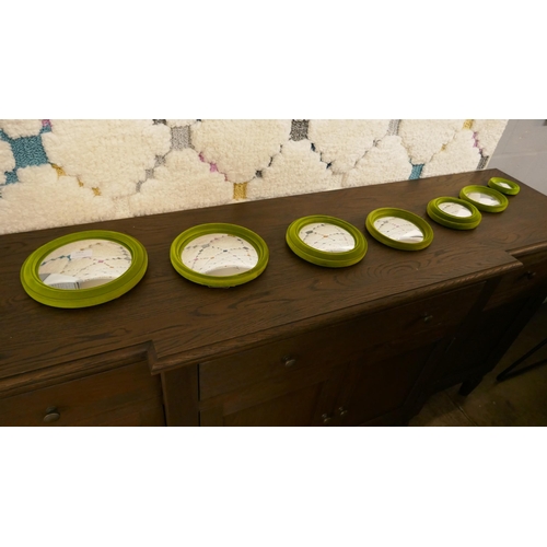1323 - Set of seven lime green flocked convex mirrors
