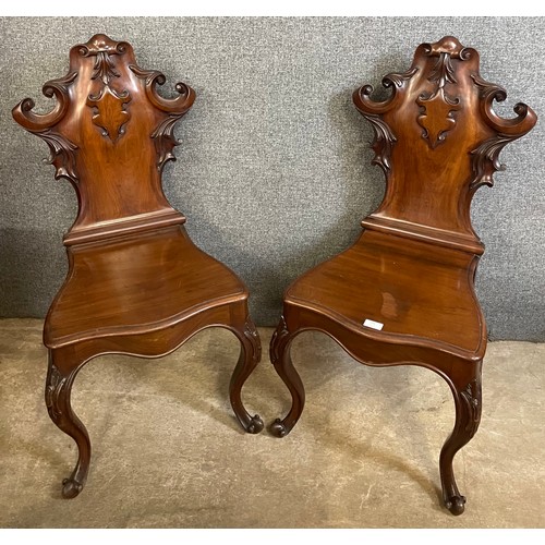 112 - A pair of early Victorian carved mahogany hall chairs