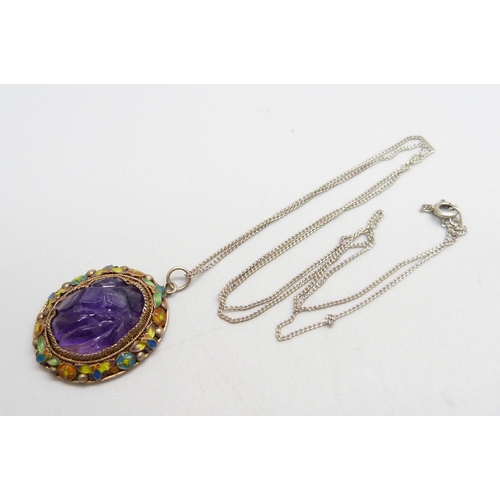 1044 - A Chinese carved amethyst and enamelled pendant on a silver chain, 22mm wide