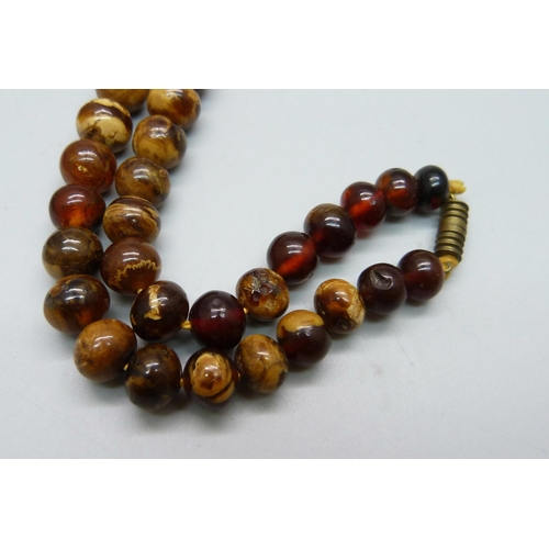 1059 - An amber necklace, 64cm, 45g, possibly reconstructed amber