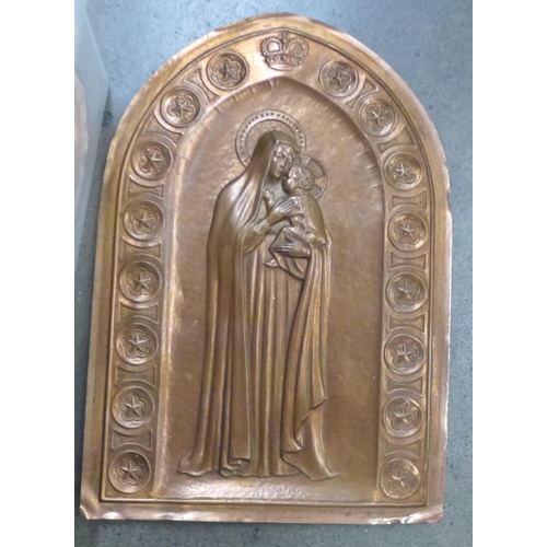 1139 - An embossed copper plaque depicting Madonna and child, three copper jelly moulds, a brass candlestic... 