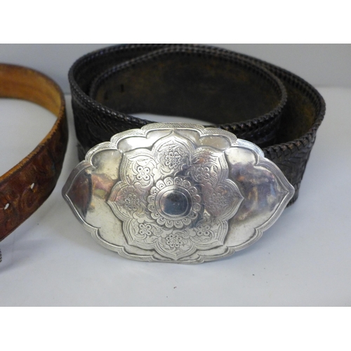 653 - A white metal belt buckle, leather belt, one other leather belt with plated buckle and a gilt metal ... 
