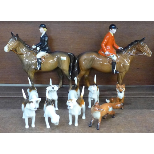 673 - A Beswick huntsman, huntswoman, (horse's ear re-glued), seven hounds and two foxes, (tail of one hou... 