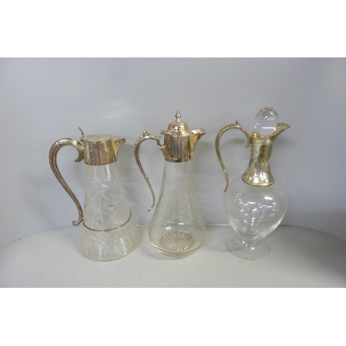 843 - Three silver topped glass claret jugs